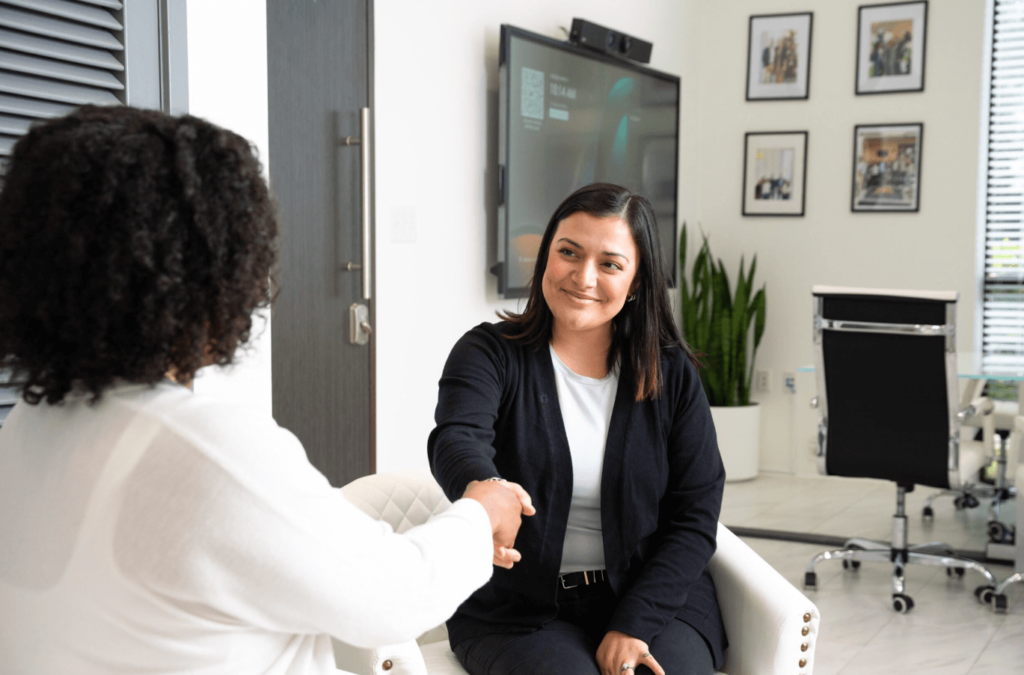 Two women shaking hands in an office setting